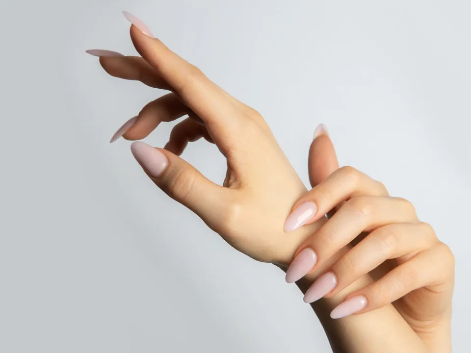 Hands with almond-shaped nude gel nails